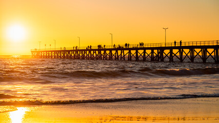 Fototapeta premium Fishermen on Port Noarlunga jetty at sunset, South Australia