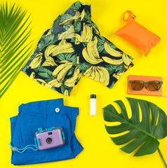 summer time outfit flay lay ready to beat the heat (banana shirt, blue shorts, sunglasses, lotion,...