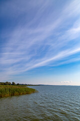 ein See bei Sonnenschein, blauer Himmel mit Wolken