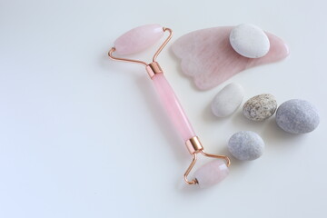 Pink face roller and guasha for skin treatment. Beauty tools. Self care device. 