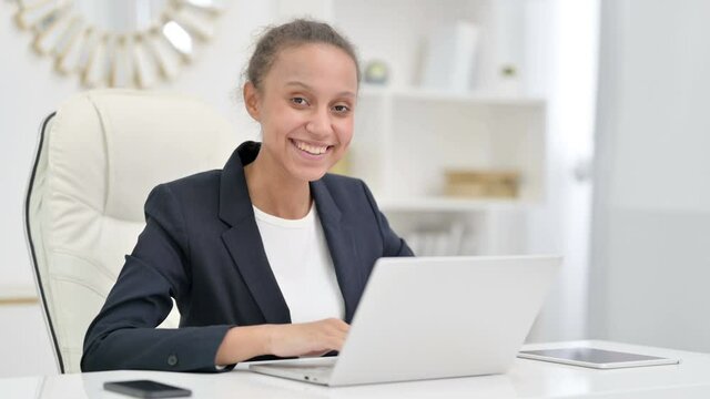 Attractive African Businesswoman with Laptop Looking at Camera in Office 