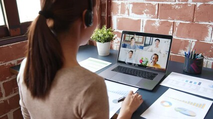 Young Asian businesswoman work at home and virtual video conference meeting with colleagues business people, online working, video call due to social distancing at home office - Powered by Adobe