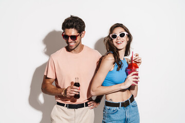 Image of cheerful beautiful couple laughing while drinking beverages