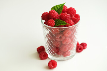 Ripe raspberries fruits in glasses on white background