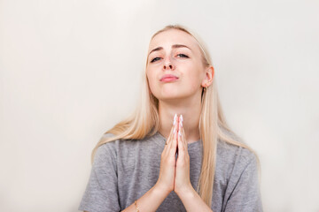 Female praying about something, isolated on beige