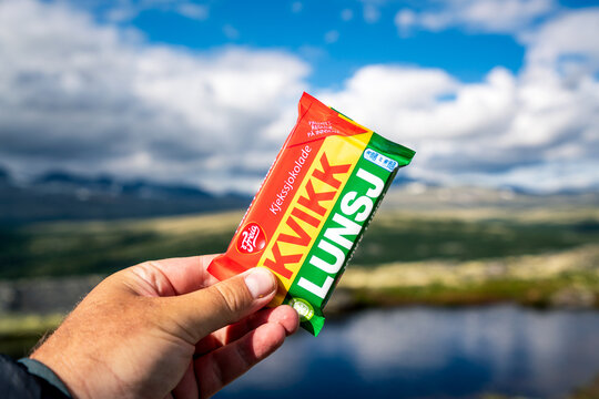 Popular norwegian chocolate bar Kvikk lunsj outdoors on a hike in the mountains. Beautiful scenery of Rondane national park in the background.