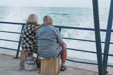 Fototapeta premium an elderly couple sitting on the beach