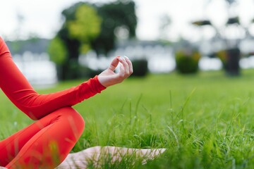 Close up of young woman doing yoga in the park with sunset