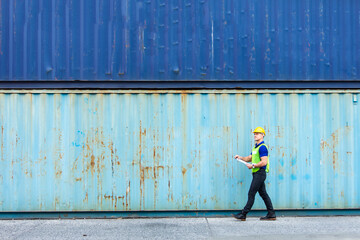 supervisor inspects wearing hardhat safety helmet working and checking control container shipping terminal at  shipping port for import and export