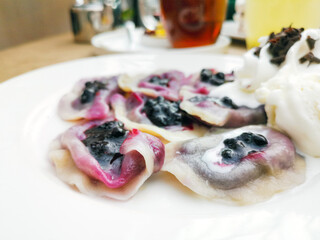 delicious sweet polish dumplings stuffed with blueberries jam and blueberries for toppings served...