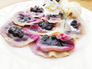 delicious sweet polish dumplings stuffed with blueberries jam and blueberries for toppings served...