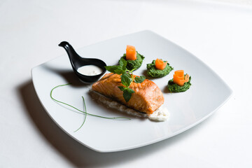 Fried salmon steaks with vegetables on white plate