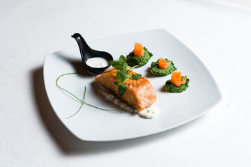 Fried salmon steaks with vegetables on white plate