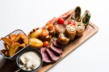 Mixed meats andvegetalbes served on wooden board