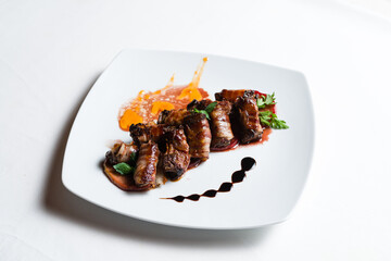 Bacon beef rolls with decoration on white plate