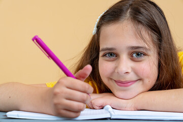 Feeling great. Pretty cheerful dark-eyed dark-haired girl smiling and doing her homework