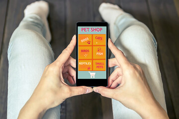 A woman is shopping at the online store. Shopping cart icon. Pet shop website.