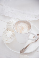 Coffee and marshmallow on a white wooden background