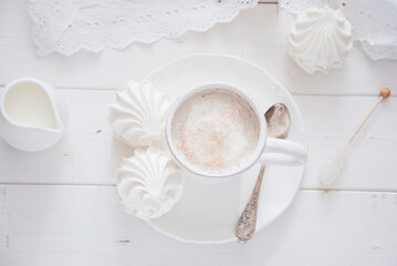 Coffee and marshmallow on a white wooden background