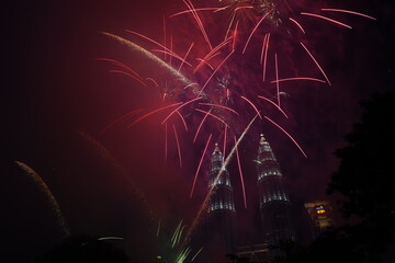 Kuala Lumpur, Malaysia – January 1, 2020: Colourful Fireworks spark during New Year at the Kuala Lumpur City. The image contains certain grain or noise and soft focus.