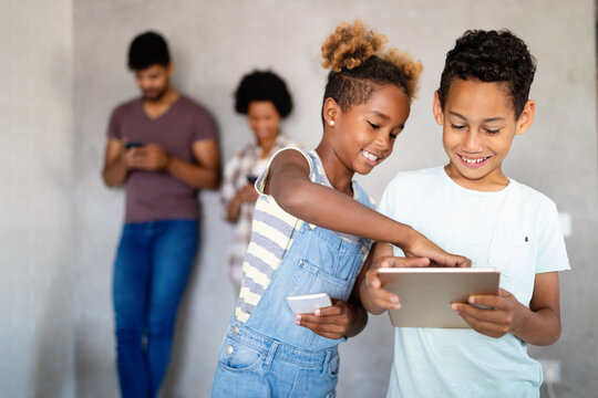 Happy children havig fun and using technology devices - Powered by Adobe