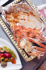 Freshly cooked grilled seafood set on a cooper tray.