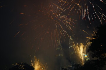 Kuala Lumpur, Malaysia – January 1, 2020: Colourful Fireworks spark during New Year at the Kuala Lumpur City. The image contains certain grain or noise and soft focus.