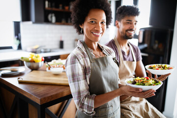 Beautiful young couple cooking healthy food together at home. Having fun in the kitchen.