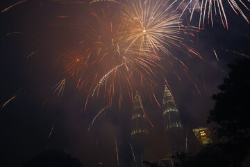 Kuala Lumpur, Malaysia – January 1, 2020: Colourful Fireworks spark during New Year at the Kuala Lumpur City. The image contains certain grain or noise and soft focus.