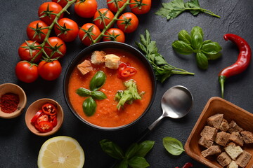 Andalusian gazpacho. Red tomato cold gazpacho soup in glass, with cucumber, onion, basil ,chili peppers and croutons.