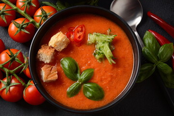 Andalusian gazpacho. Red tomato cold gazpacho soup in glass, with cucumber, onion, basil ,chili peppers and croutons.