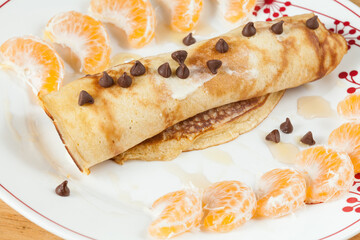 Tasty And Healthy Breakfast; Pancakes Rolled Up With Dietary Chocolate Chips And Honey.