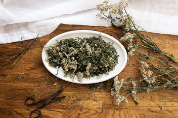 collection of herbs, dried yarrow on a wooden brown background, kitchen board,