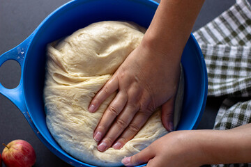 woman kneading yeast dough for pie