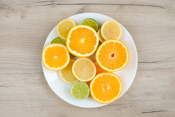 Plate with cut citrus on wooden background. Top view. Healthy food concept.