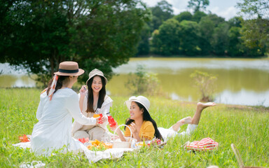  Asian woman friends. They are having a picnic, eating in the morning