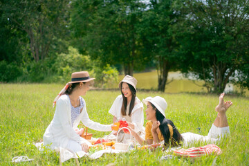  Asian woman friends. They are having a picnic, eating in the morning In the park