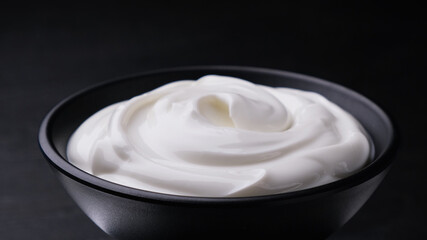 Bowl of sour cream on black background