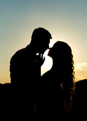 Marvelous silhouette of a loving couple on a background of evening sky, sunset