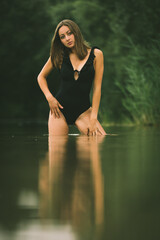 Junge Frau im Monokini genießt eine Abkühlung im Badesee