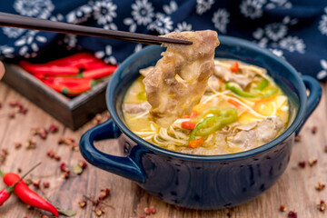 A bowl of beef in Flammulina mushroom and sour soup on the wooden table	
