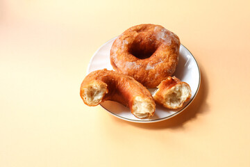 Plate with donuts on a yellow background, close-up, place for the inscription