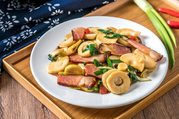 A plate of winter bamboo shoots bacon on a wooden table