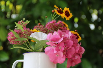 Henkeltopf mit Blumen im Garten