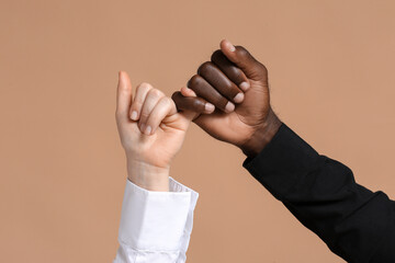 Hands of Caucasian woman and African-American man on color background. Racism concept