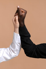Caucasian woman and African-American man holding hands together on color background. Racism concept