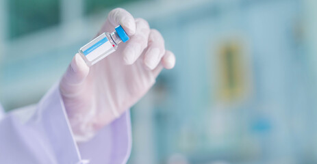 close up on scientist hand holding vaccine bottle for medical sample set at pharmaceutical operation room or scientific laboratory for fight and protect coronavirus (MERS-n COV) concept	