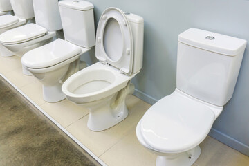 Ceramic toilet bowls in white. Plumbing trade in the store.