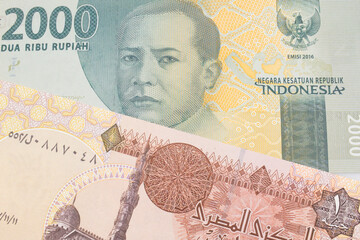 A macro image of a grey two thousand Indonesian rupiah bank note paired up with a one pound banknote from Egypt.  Shot close up in macro.