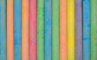 Group of colorful chalk on blackboard or chalkboard as background. School education, dark wall backdrop or learning concept.
